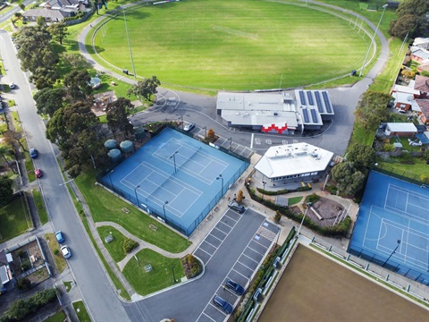 Aerial view of oval, tennis courts and building