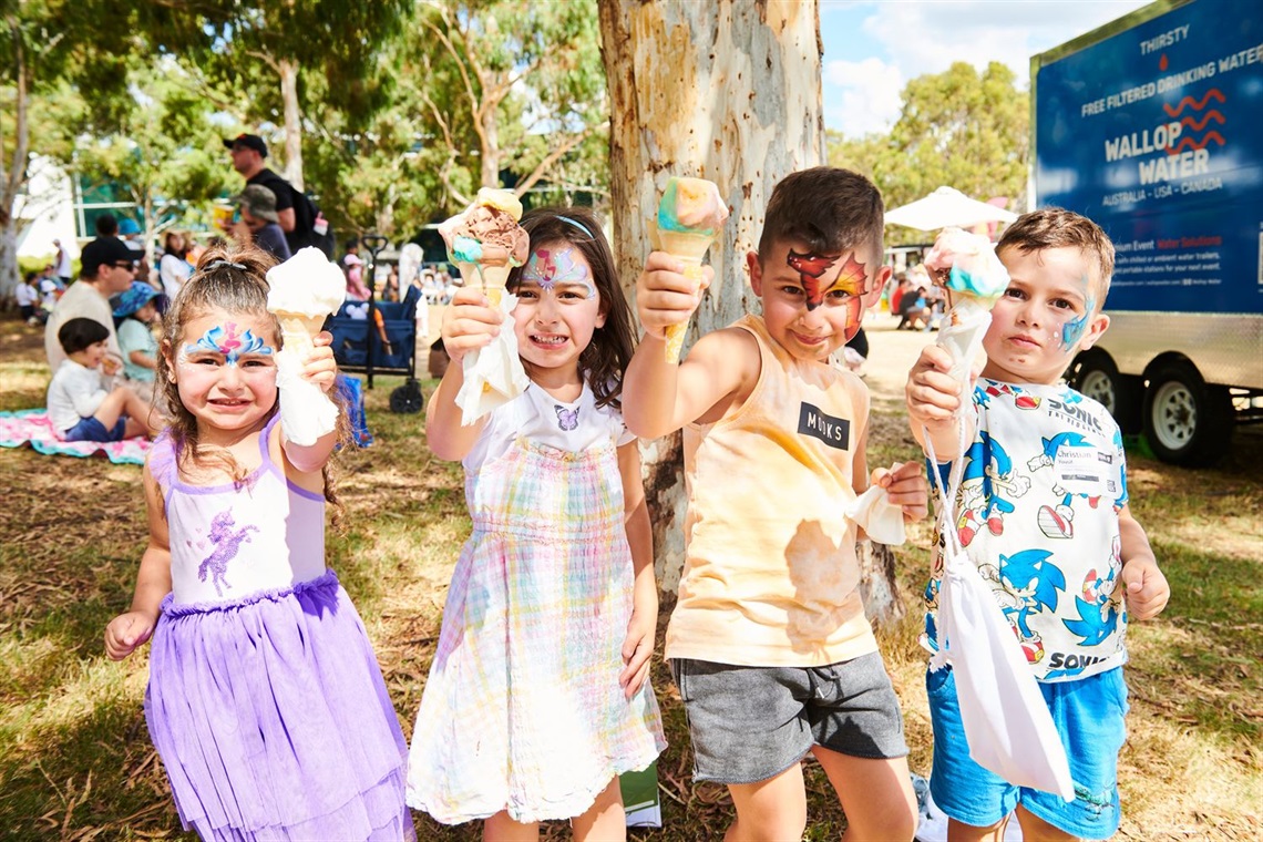 A group of kids enjoying ice cream in a festive outdoor setting.